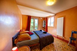 a bedroom with a bed in a room with orange walls at Eco-hôtel et Yourtes du Mercantour in Guillaumes