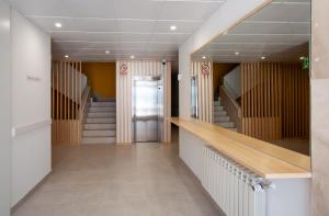 um corredor com escadas que conduzem a uma porta num edifício em Apartamentos Atempo Aranjuez em Aranjuez