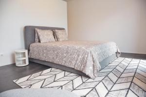 een slaapkamer met een bed, een stoel en een tapijt bij Front Lake Apartment Meli With View Feel Ticino Feel Home in Melide