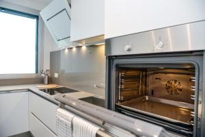 een keuken met een oven en witte kasten bij Front Lake Apartment Meli With View Feel Ticino Feel Home in Melide