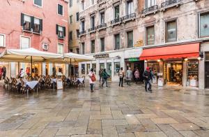 ヴェネツィアにあるカ レオン ドーロの傘を持って街を歩く人々