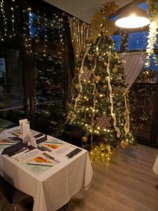 a christmas tree in a room with a table at Dukes Folly Hotel in Southport