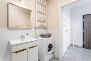 biała łazienka z pralką i umywalką w obiekcie Chill Apartments Ursus w Warszawie