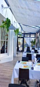 a restaurant with white tables and chairs and windows at Dukes Folly Hotel in Southport