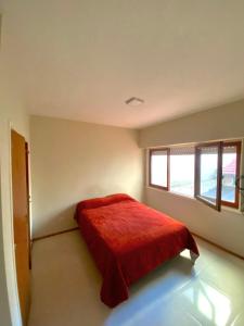 1 dormitorio con 1 cama con manta roja en Departamento zona playa grande en Mar del Plata