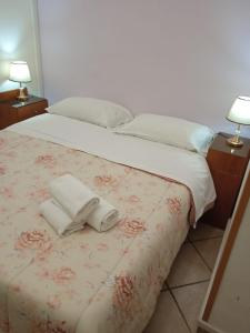 una camera da letto con un letto e due asciugamani di Atlantic Ostello B&B a Napoli