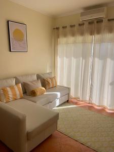a living room with a white couch and a window at Condominio do Mar in Lagos