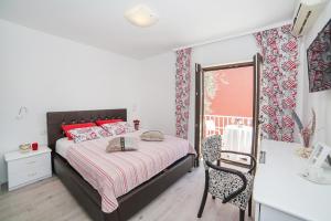 a white bedroom with a bed and a balcony at Villa Mona 2 in Budva