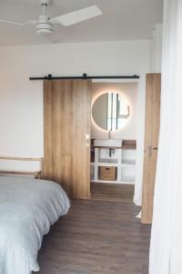 a bedroom with a large bed and a mirror at Villa romantique, Rêve d'ailleurs, saint leu, la Réunion in Saint-Leu