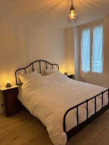 a bedroom with a large bed with white sheets at Bonheur en Seine, Piscine, Vue Seine in Poissy +8 photos
