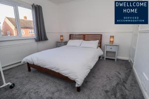 a bedroom with a large bed with white sheets and a window at Dwellcome Home Ltd 3 Bedroom Boldon House - see our site for assurance in Boldon