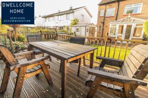 a wooden table and two benches on a deck at Dwellcome Home Ltd 3 Bedroom Boldon House - see our site for assurance in Boldon