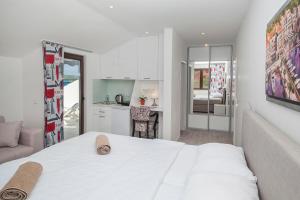 a bedroom with a white bed and a kitchen at Villa Mona 2 in Budva