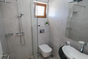 La salle de bains est pourvue d'une douche, de toilettes et d'un lavabo. dans l'établissement Villa Mona 2, à Budva