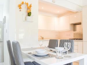 a white kitchen with a dining table and chairs at The Lodge At Forbury Cottage in Kimbolton