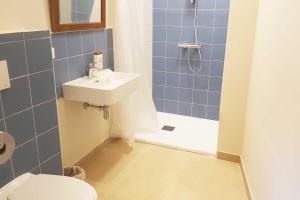 a bathroom with a toilet and a sink and a shower at A la belle étoile in Mellionnec