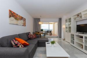 salon z kanapą i telewizorem w obiekcie Atico Lujoso w mieście Torremolinos