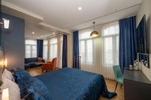 a bedroom with a blue bed and a living room at Juno Hotel Taksim in Istanbul
