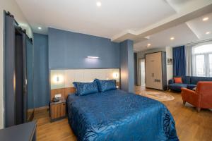 een hotelkamer met een blauw bed en een bank bij Juno Hotel Taksim in Istanbul
