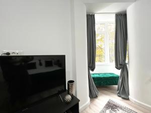 a living room with a flat screen tv and a window at Green Spot - Premium Studio - Sanador Victoriei in Bucharest