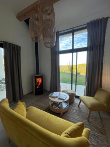 uma sala de estar com um sofá amarelo e uma lareira em La Bergerie du Roy-Chambres D'hôtes- em Rognes