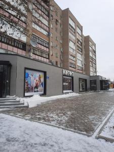 un edificio con un grande cartello sopra nella neve di Уютная и просторная квартира в 50 метрах от городского парка a Petropavlovsk