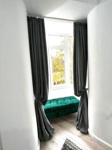 a window with a green couch in front of a window at Green Spot - Premium Studio - Sanador Victoriei in Bucharest