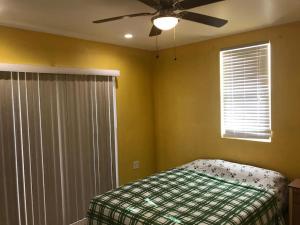 a bedroom with a bed and a ceiling fan at palmvillo master suit 
