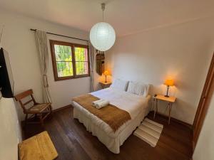 a bedroom with a bed and two tables and a window at El Arbol Hostel in La Serena