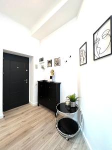 Habitación con mesa de cristal y puerta negra. en Green Spot - Premium Studio - Sanador Victoriei, en Bucarest