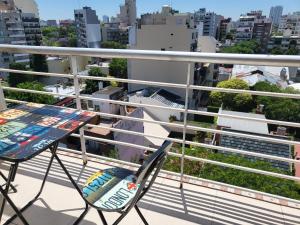 una silla en el balcón con vistas a la ciudad en Depto 2 ambientes super luminoso en Buenos Aires