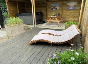 un banco de madera sentado en una terraza de madera en Bed and Breakfast Heerenveen Centrum met Privé Sauna en Jacuzzi, en Heerenveen