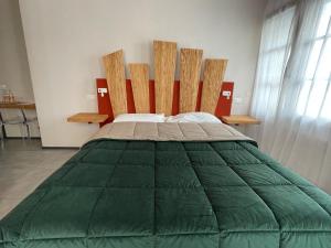 アレッツォにあるB&B VIA ROMA 25のベッド1台(緑の掛け布団付)