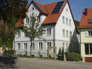 una casa blanca con techo solar en una calle en Serviced Apartments Hohenlohe, 