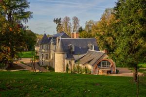 una casa grande en un campo verde con árboles en Domaine de la Commanderie de Ballan, en Ballan-Miré