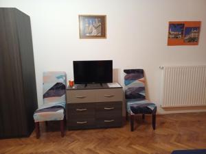 sala de estar con 2 sillas y TV en Buda Trió Apartments, en Budapest