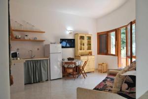 een keuken en een woonkamer met een witte koelkast bij La Sirenetta tra mare e collina in Sperlonga