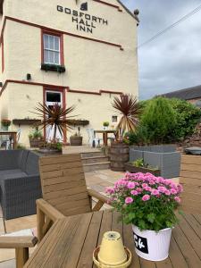 a patio with a table and flowers in front of a restaurant at Mill Cottage Modern Boutique Cosy Home in Lake District Village near Scafell in Gosforth