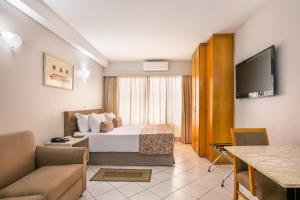 a hotel room with a bed and a tv at Plaza Inn American Loft in Sao Paulo