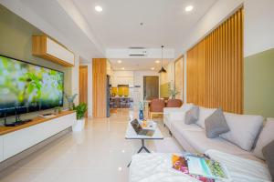 ein Wohnzimmer mit einem Sofa und einem Flachbild-TV in der Unterkunft 9TRIP STAY in Soho Residence - Service Apartment in Ho-Chi-Minh-Stadt