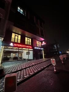 uma linha de comboio em frente a um edifício à noite em Intercity Airport Hotel em Arnavutköy