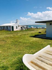 un edificio sentado sobre un campo de hierba en El fortín del Rubio, en Cabo Polonio