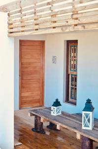 a room with a wooden table and a wooden door at El fortín del Rubio in Cabo Polonio