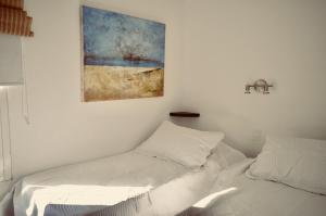 a bedroom with two beds and a painting on the wall at El fortín del Rubio in Cabo Polonio