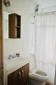 a white bathroom with a toilet and a sink at El fortín del Rubio in Cabo Polonio