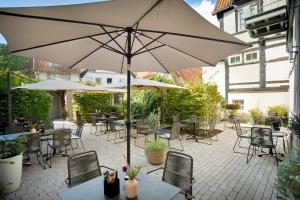 a patio with tables and chairs with an umbrella at Wertschätzer Hotel - Krumme Str in Detmold