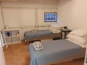 a small room with two beds and a window at Ragnhilds Gård, Hostel Vandrerhjem in Nyord