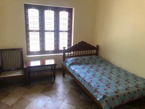 um quarto com uma cama, uma mesa e uma janela em Konni Town Central House with AC rooms em Koni