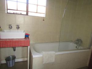 a bathroom with a bath tub and a sink at Mafube Mountain Retreat in Fouriesburg +32 photos