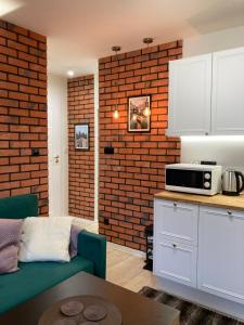 kuchnia z salonem z ceglaną ścianą w obiekcie Apartament BB I na Kiepury w mieście Krynica Zdrój
